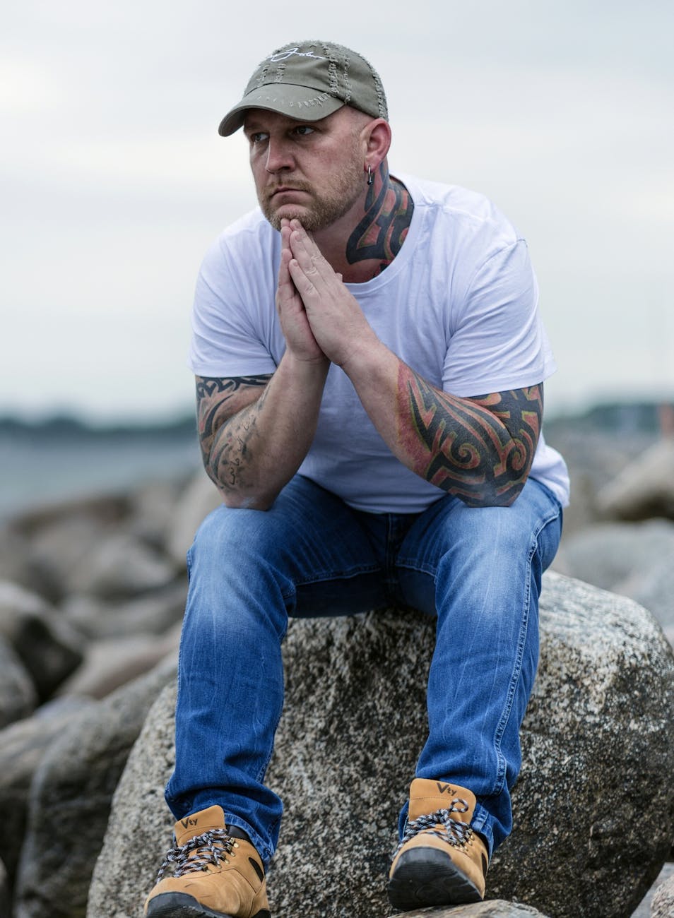 man sitting on gray rock on selective focus photo